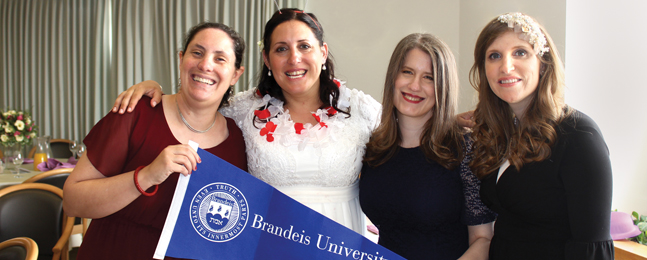 Jill Virag and three female friends hold a Brandeis pennant at her wedding